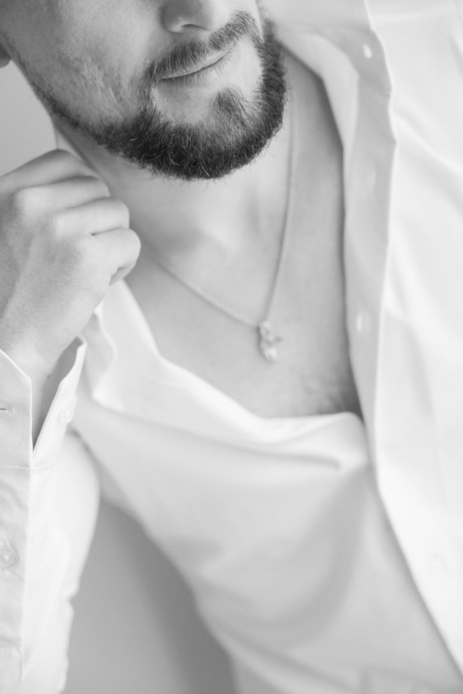 Close-up black and white photo of neckline with pendant necklace.