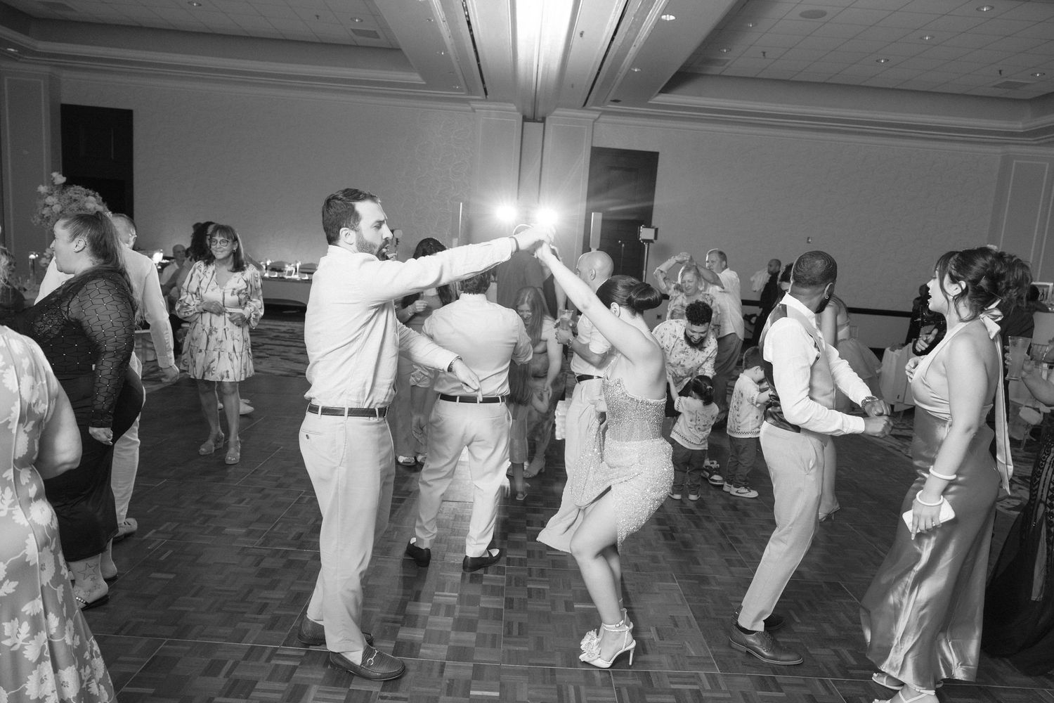 Wedding guests performing a synchronized line dance at the reception.