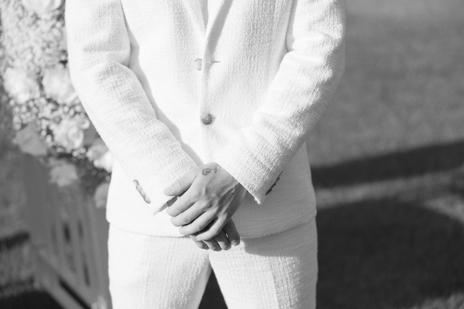 Detail shot of white formal attire against a monochrome background.
