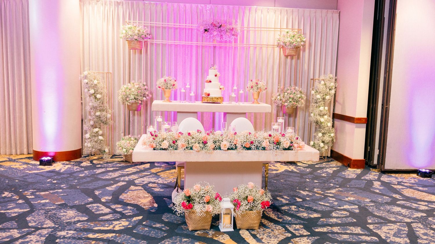 Panoramic view of a wedding reception hall decorated in pink and white.
