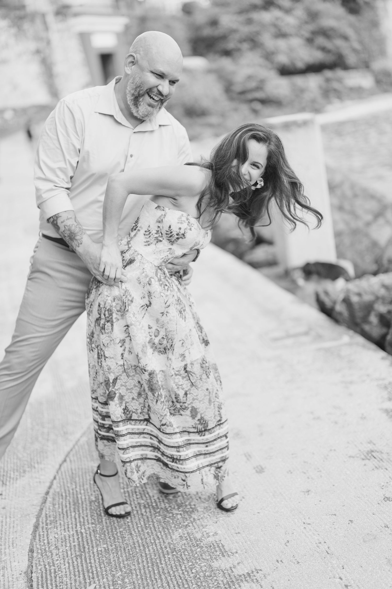 Black and white candid moments of a couple on a textured pathway.