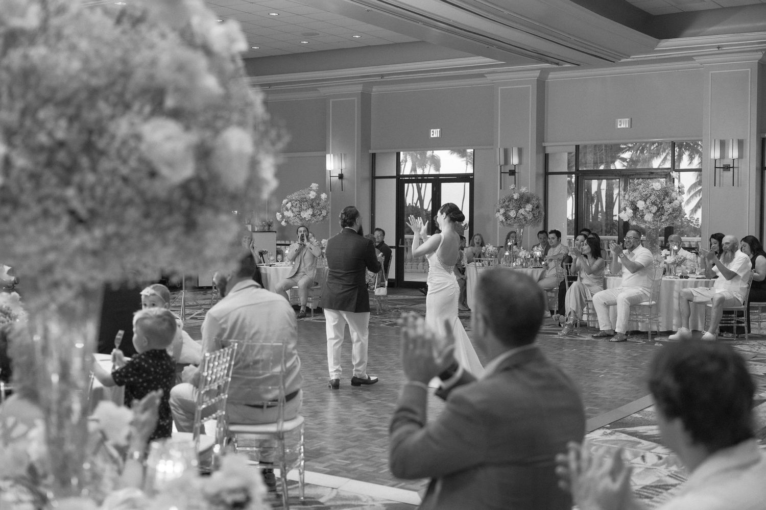 Black and white image captures dancing couples during a formal wedding reception.