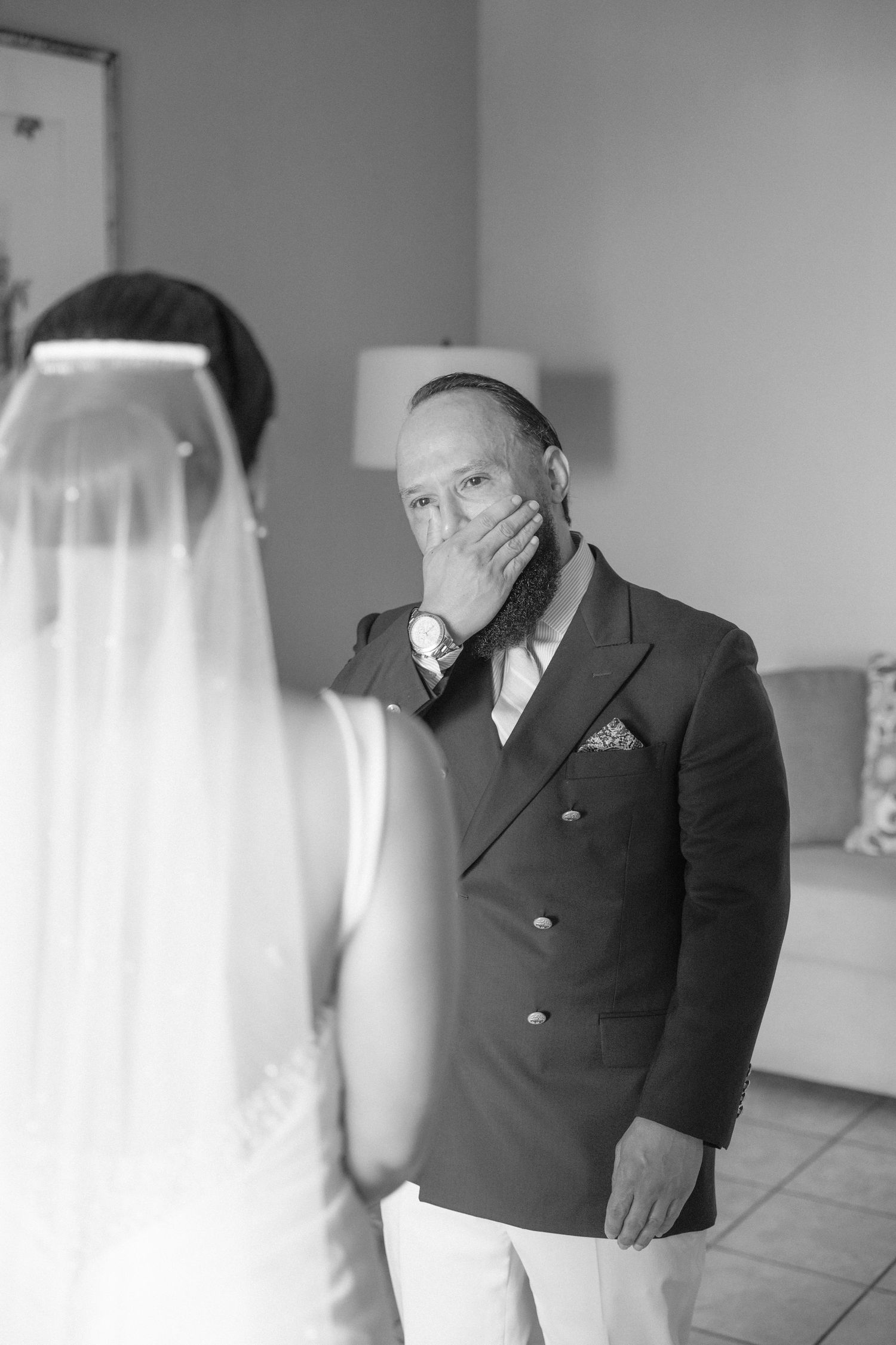 An emotional reaction during a first look wedding moment in a hotel suite.