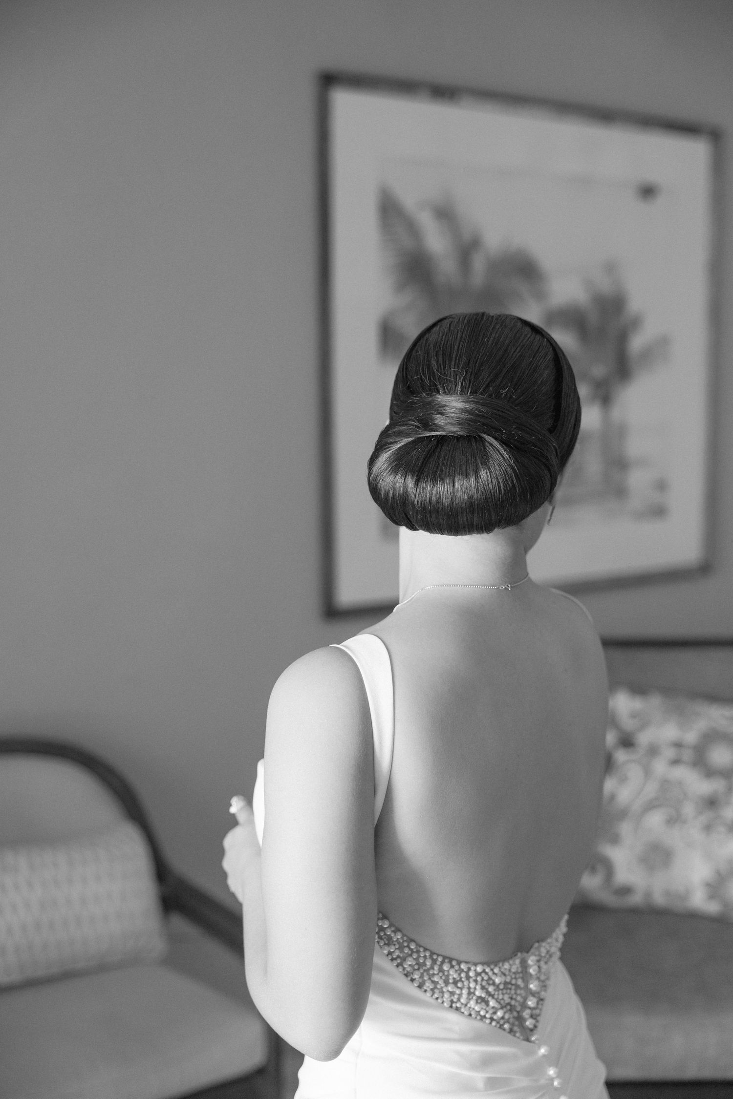 Back view of elegant updo hairstyle with beaded dress details.