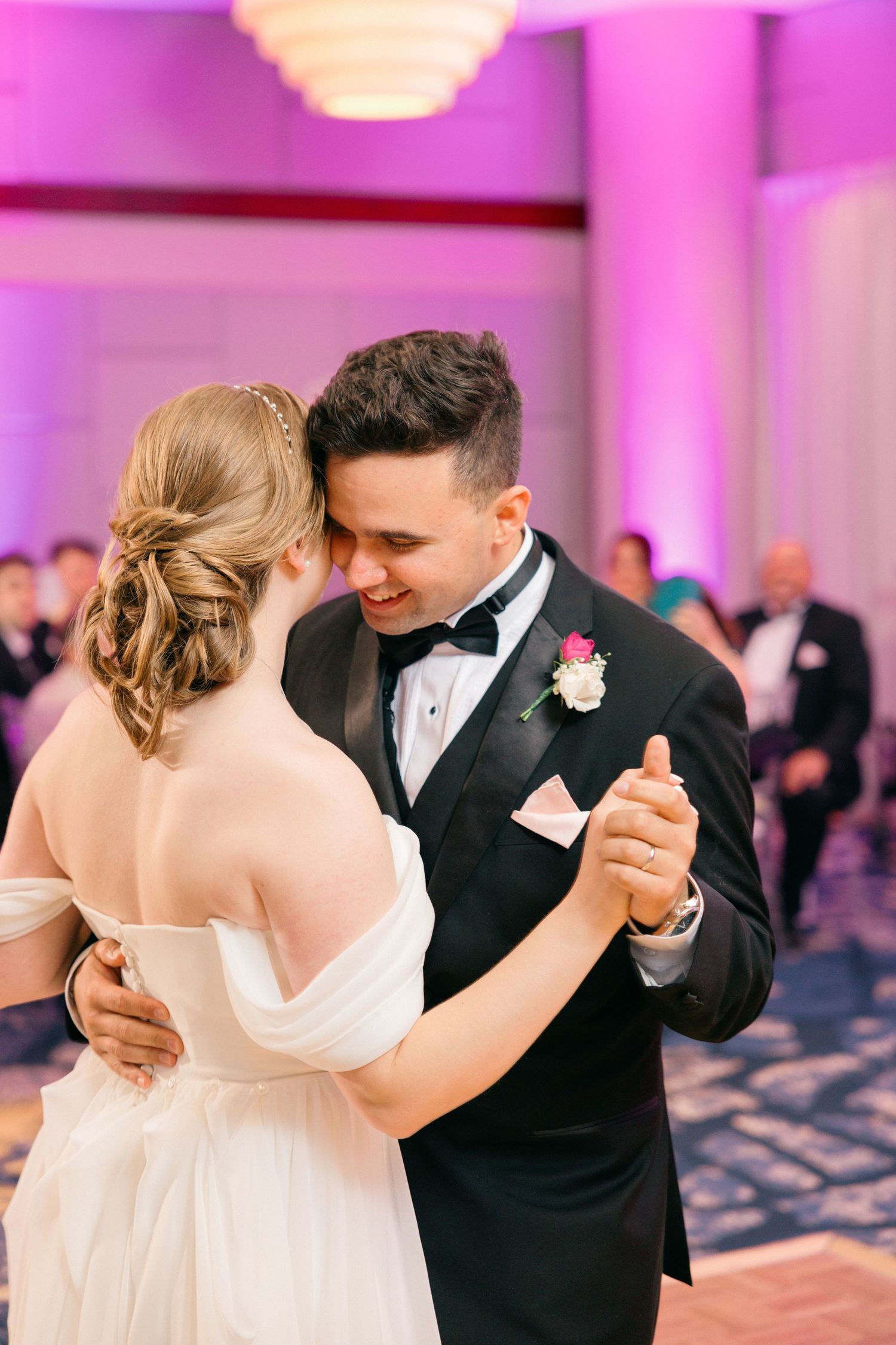 Romantic dance sequence in a ballroom with pink lighting and elegant decor.