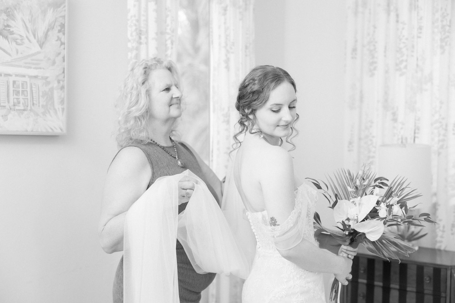 Black and white photo of bridesmaids sharing intimate moments during wedding preparations.