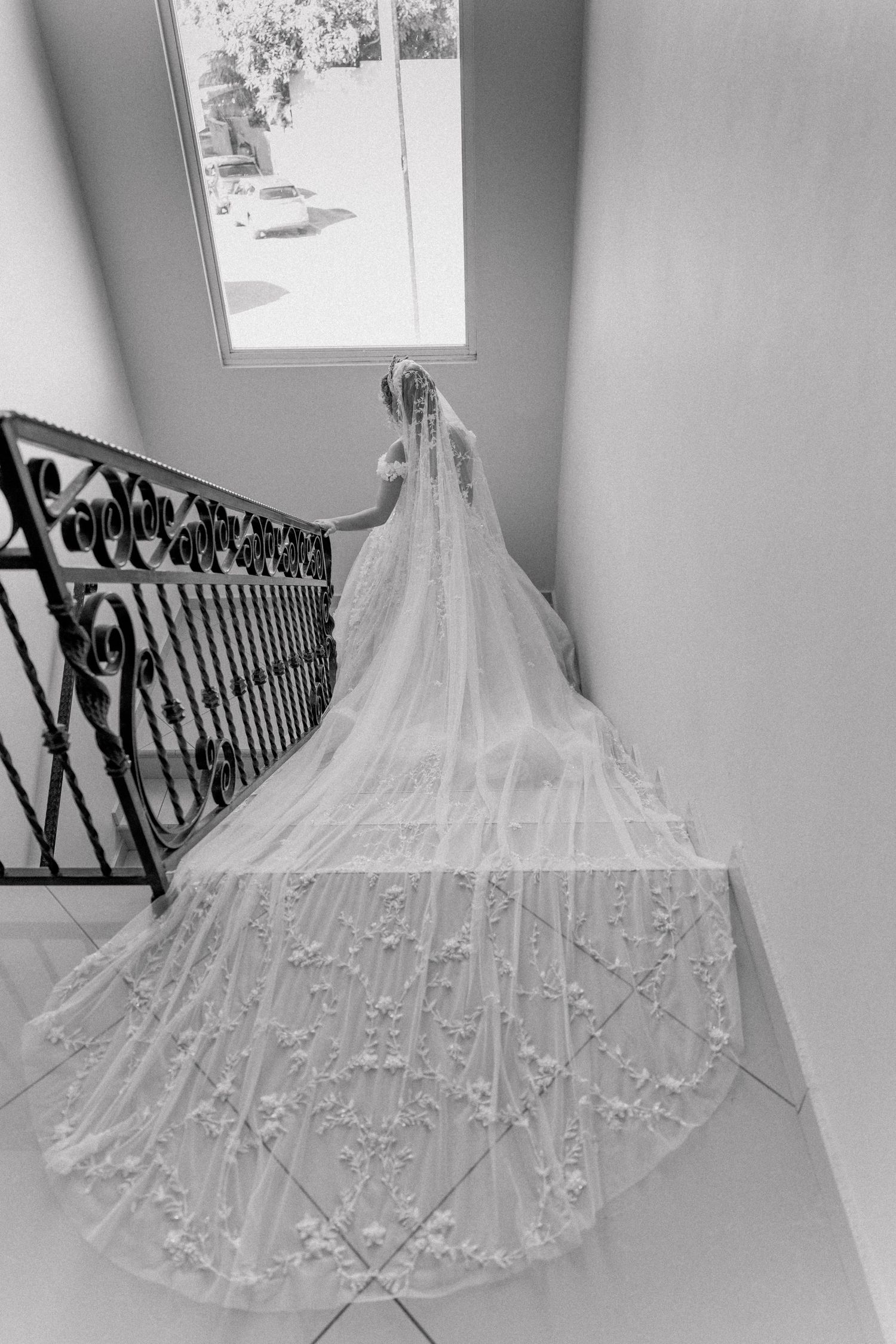 Detailed black and white photo of intricate lace wedding dress train.