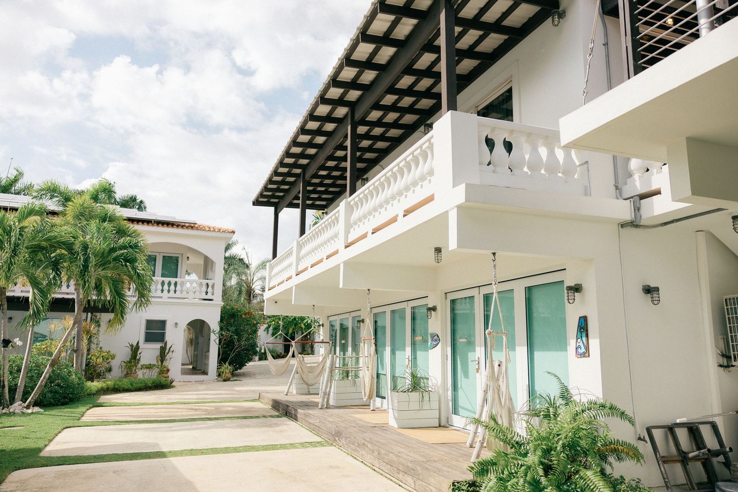 Elegant white wedding venue with covered walkways and tropical landscaping.