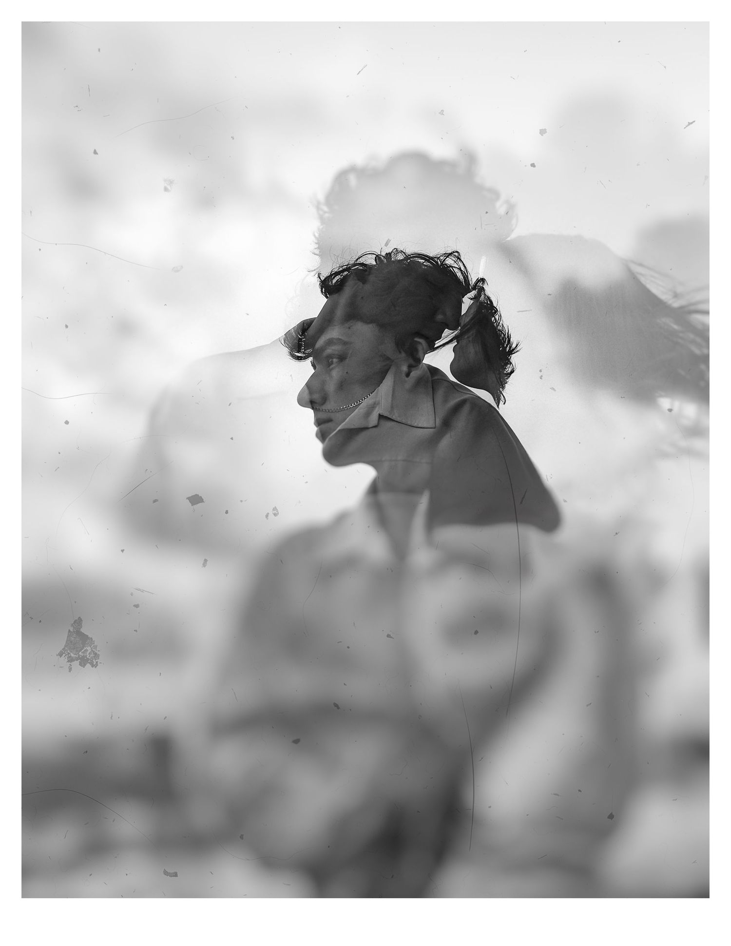 Artistic black and white silhouette portrait against cloudy sky.