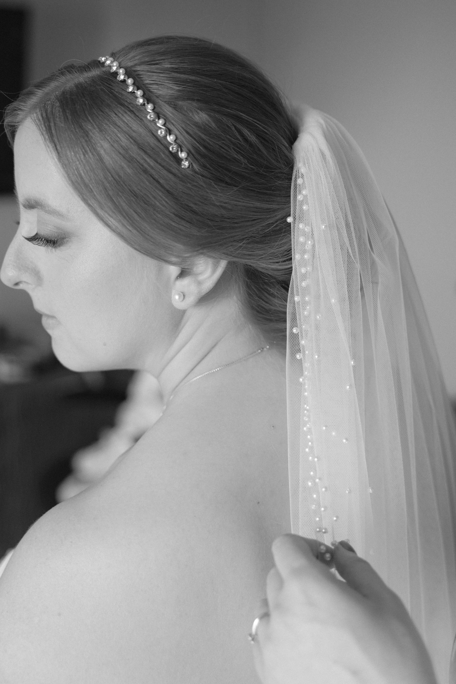 Side profile shots of a pearl-adorned wedding veil in black and white.