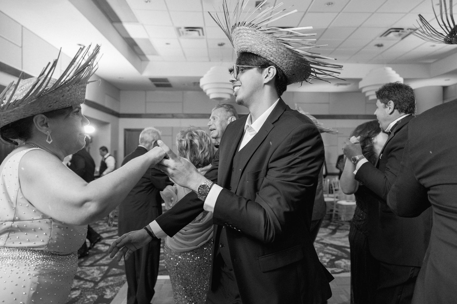 Black and white photo sequence of wedding guests dancing in formal attire.