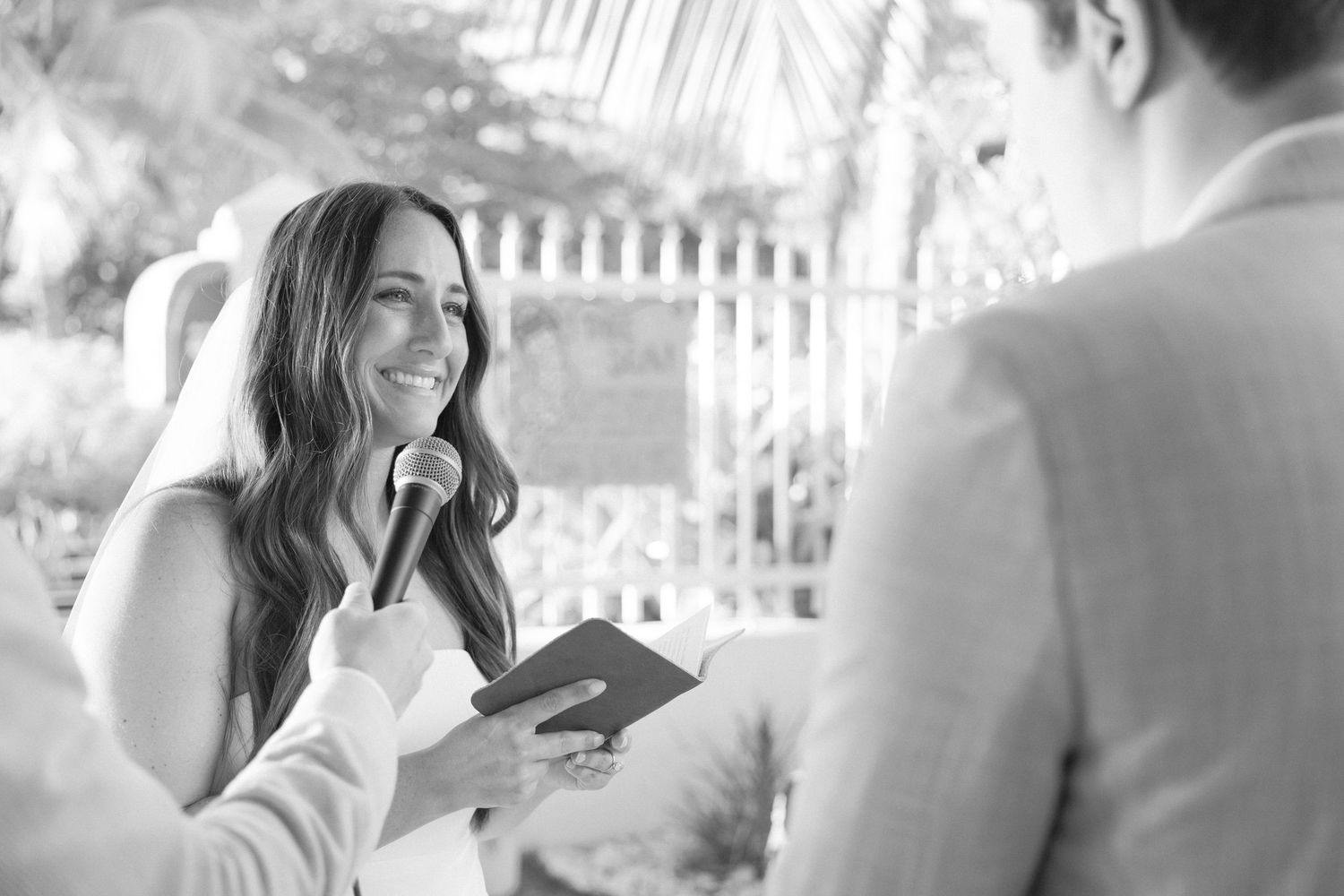 Black and white photo of an emotional moment during an outdoor wedding ceremony.