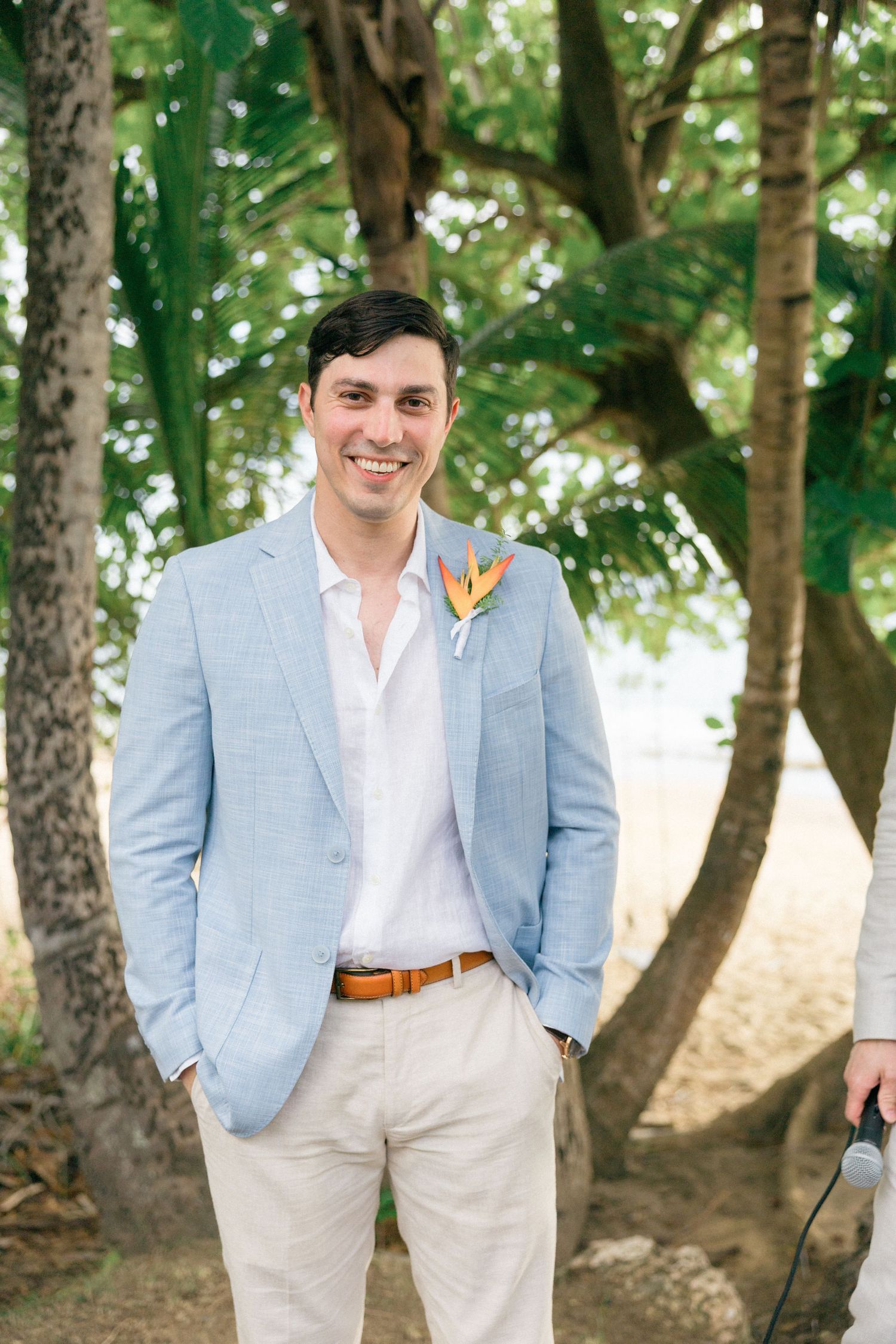 Light summer wedding attire featuring pale blue blazers and khaki pants in garden setting.