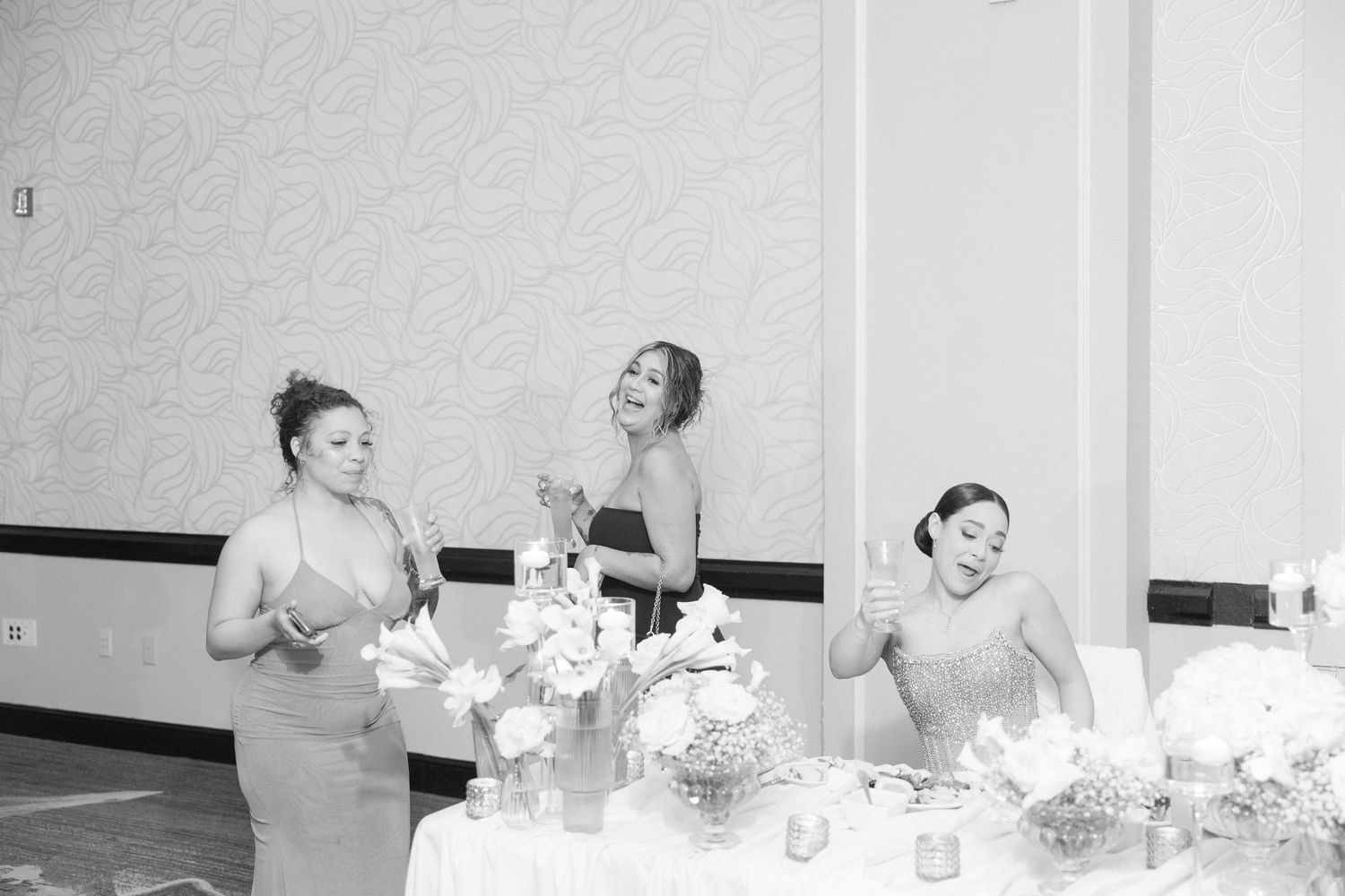 Wedding party members sharing emotional embraces during reception.