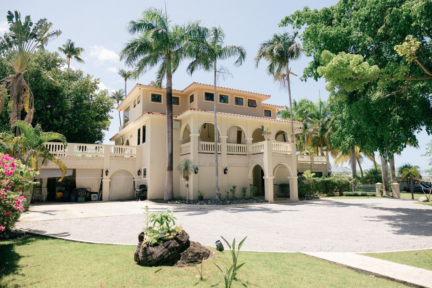 Mediterranean-style venue exterior with palm trees and cream colored architecture.
