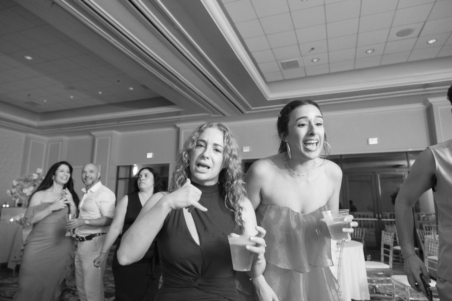 Wedding guests dancing and celebrating together on the dance floor at a reception.
