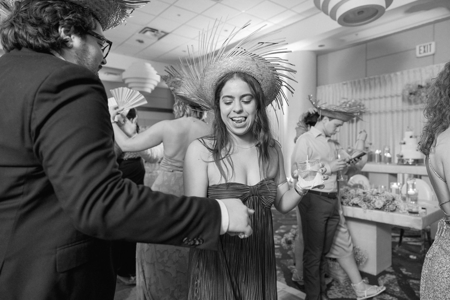Candid moments of wedding guests dancing and celebrating at an indoor reception.