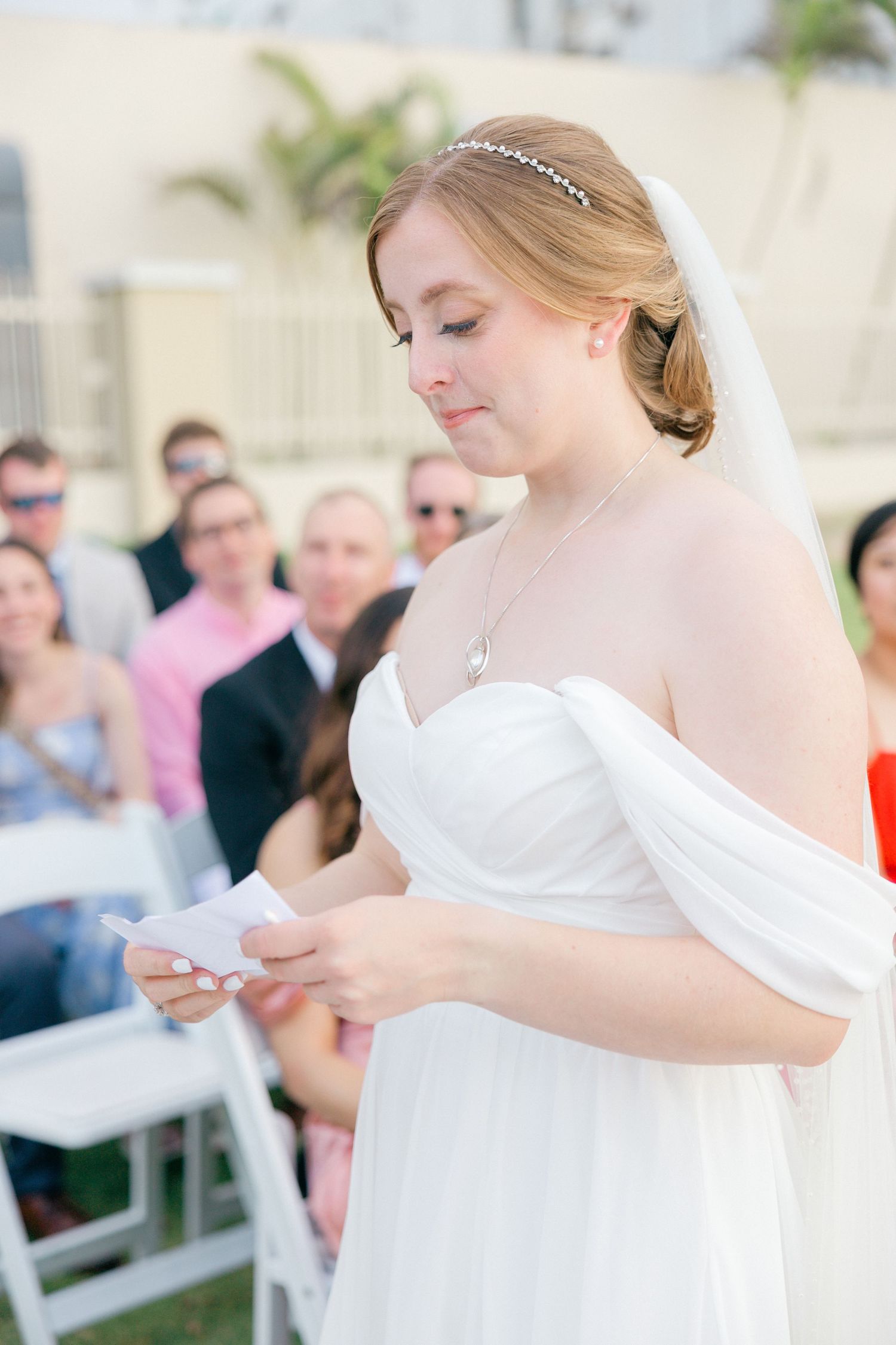 Elegant white wedding dress detail with sweetheart neckline against outdoor setting.