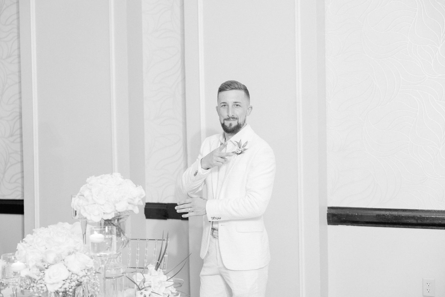 Wedding reception setup with elegant white decor and floral arrangements.