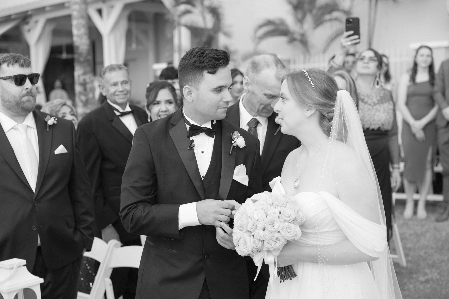 Black and white candid shots of wedding ceremony moments with guests and wedding party.