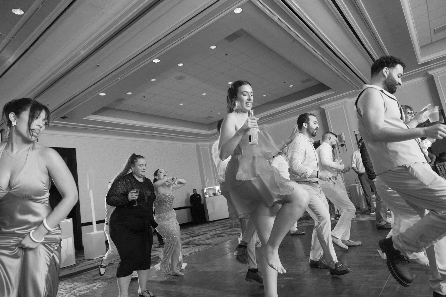 Wedding guests performing synchronized dance moves during a reception celebration.