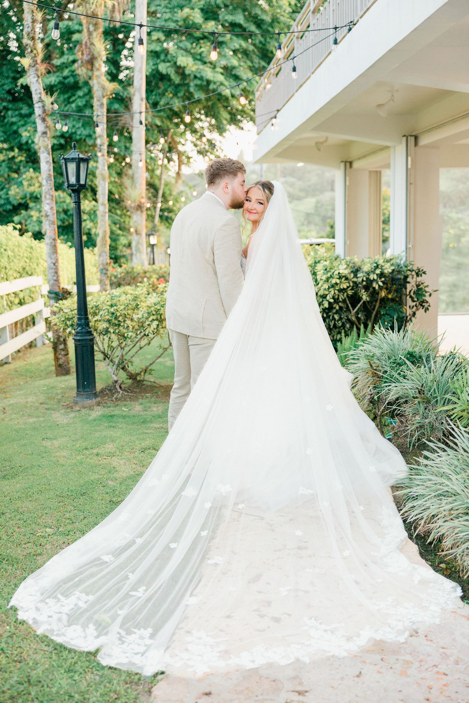 Elegant wedding photos captured in a lush garden setting with flowing white gown and veil.