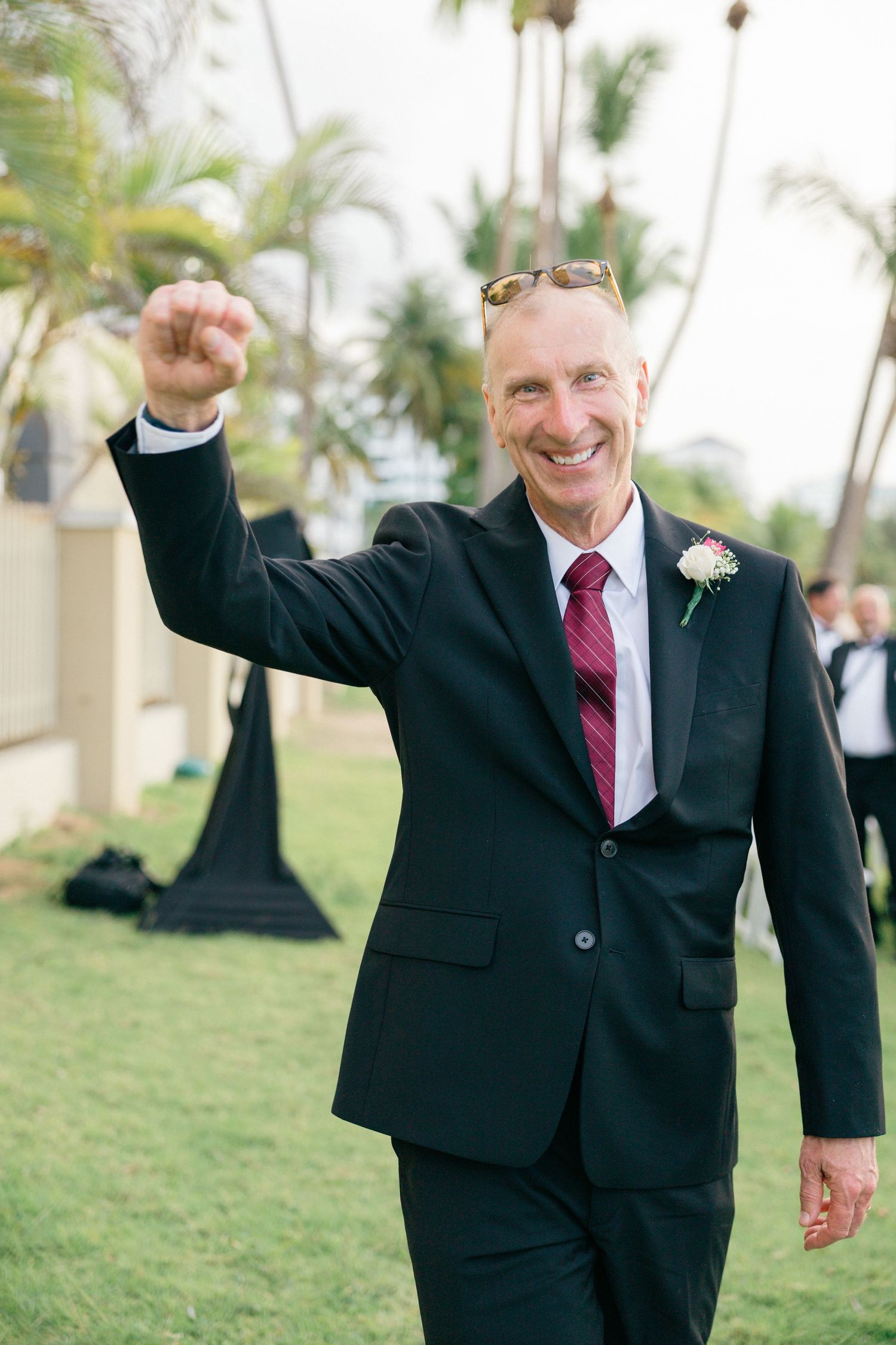 A celebratory moment captured on a grassy lawn with palm trees.
