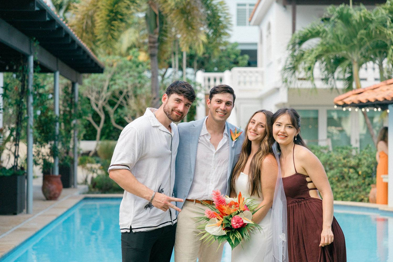 Wedding party members share laughs during outdoor photo session at a resort venue.