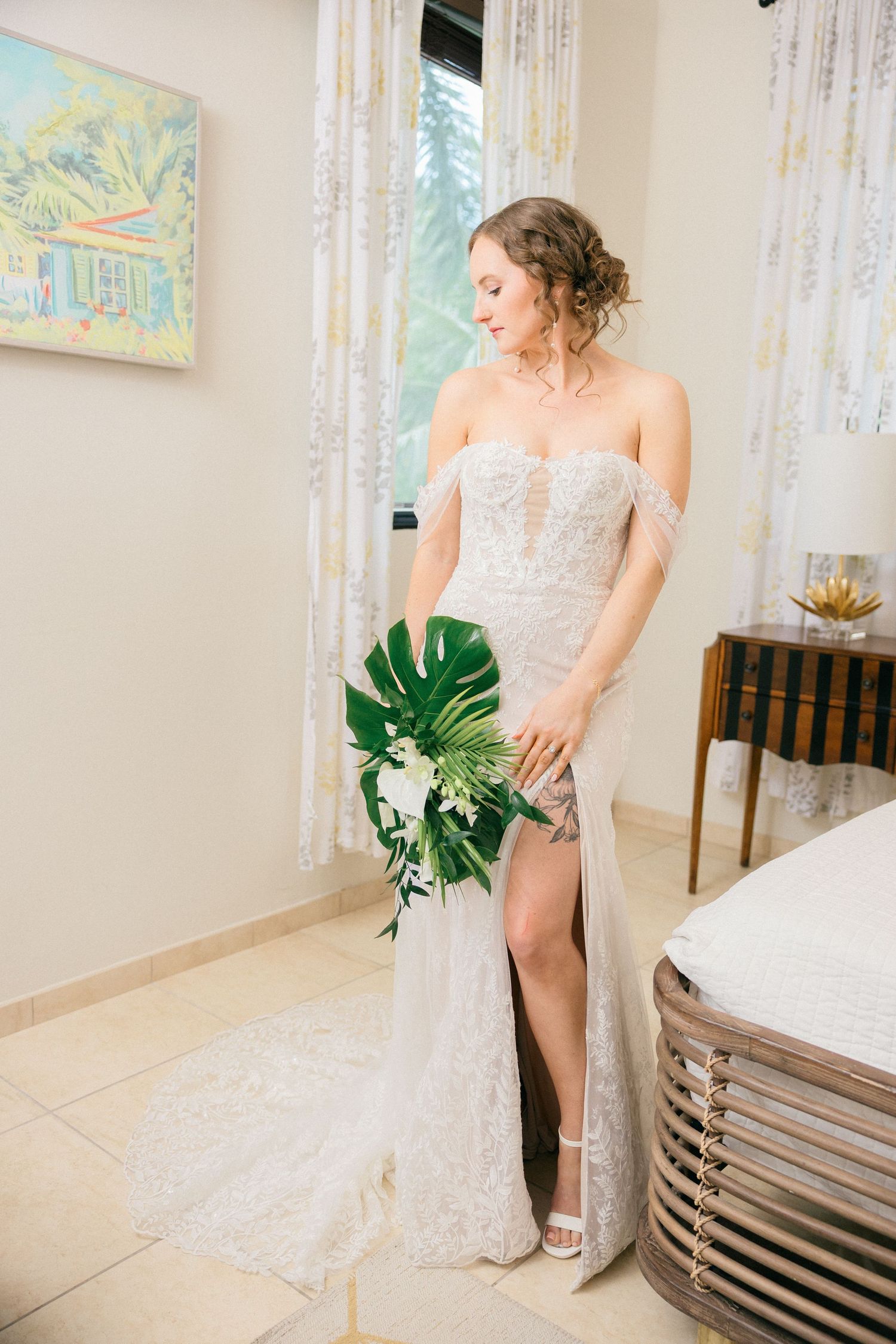 Elegant bridal boudoir session with tropical monstera leaf in a bright interior setting.