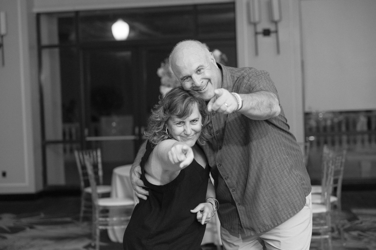 Joyful dancing and celebration captured in black and white at a wedding reception.
