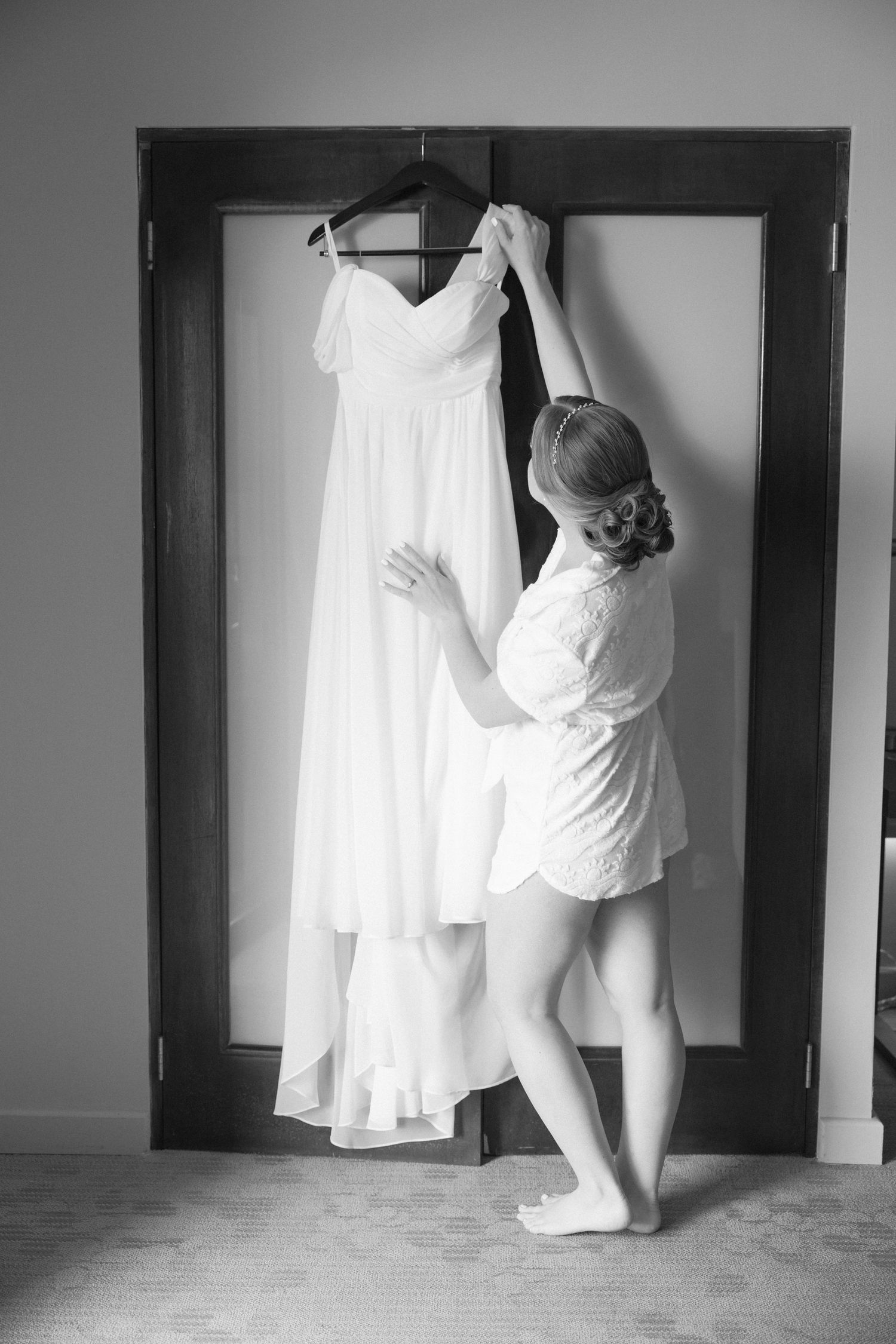 Series showing white wedding dress being hung and prepared in doorway.