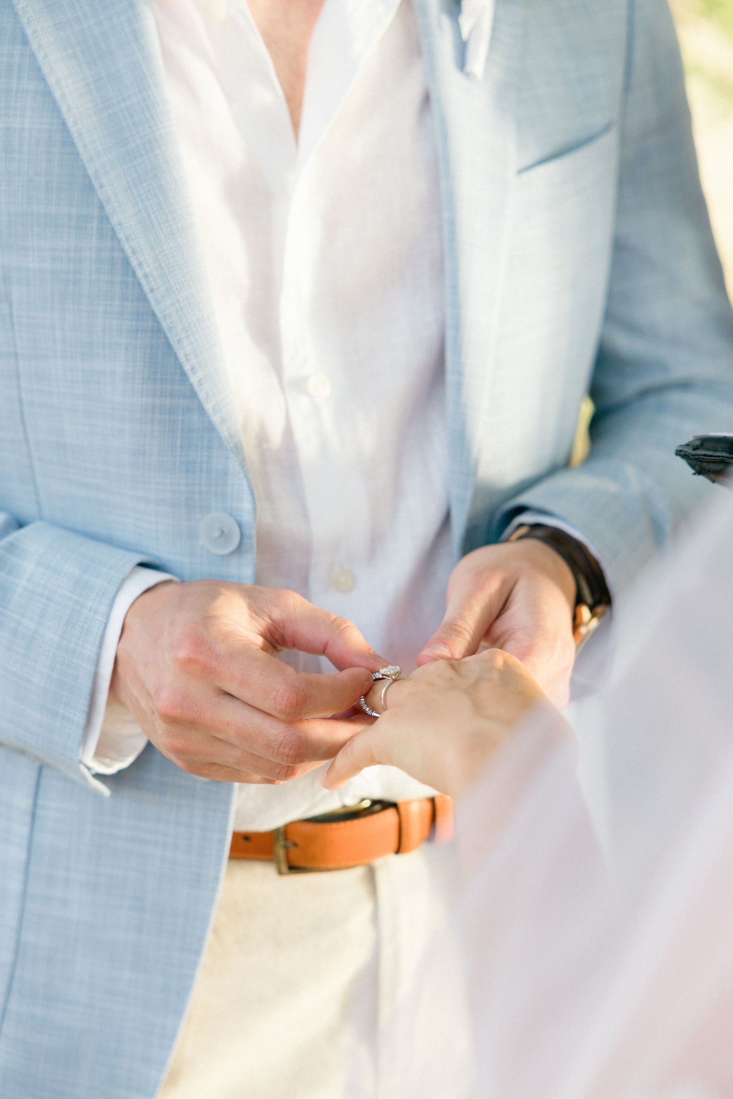 Detail shots of hands and rings during wedding ceremony in natural lighting.