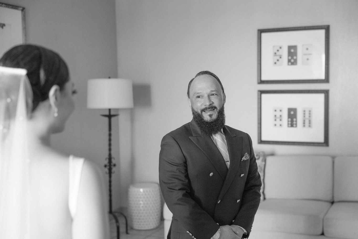 An emotional first look reaction in a hotel room with modern decor and artwork.