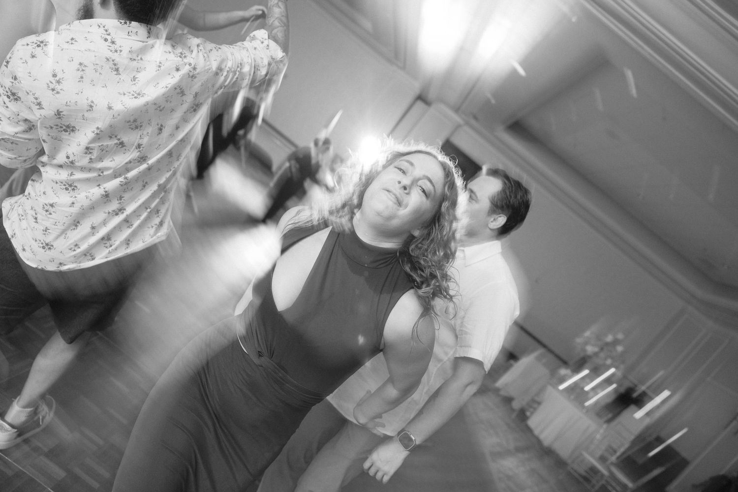 Wedding party dancing and celebrating on a dance floor at a reception.