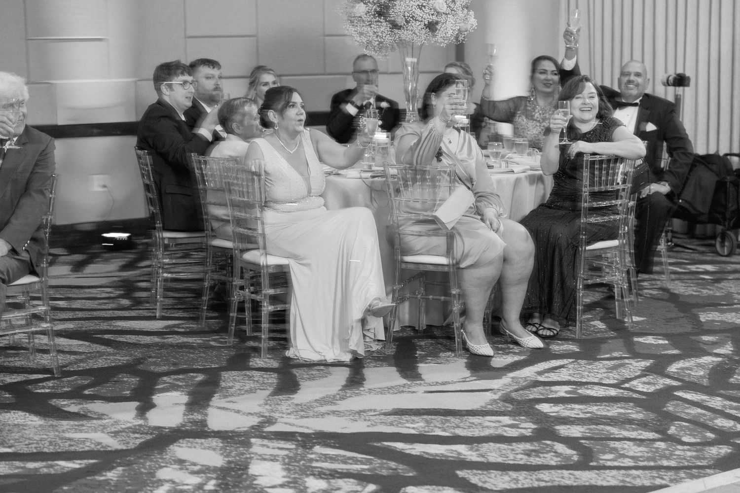 Vintage black and white photo of guests seated in chairs at a formal event.