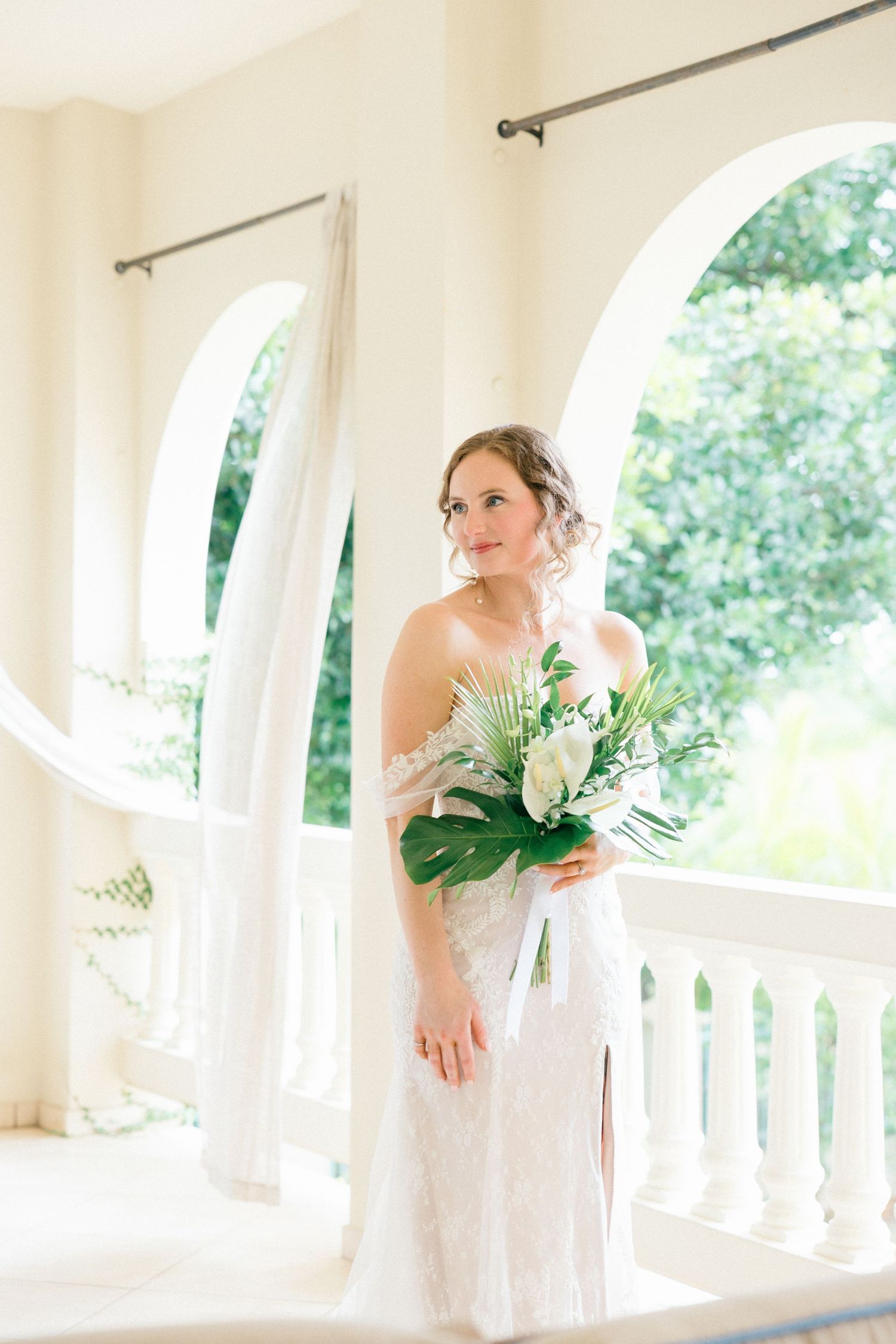 White wedding dress against arched windows in a classic venue.