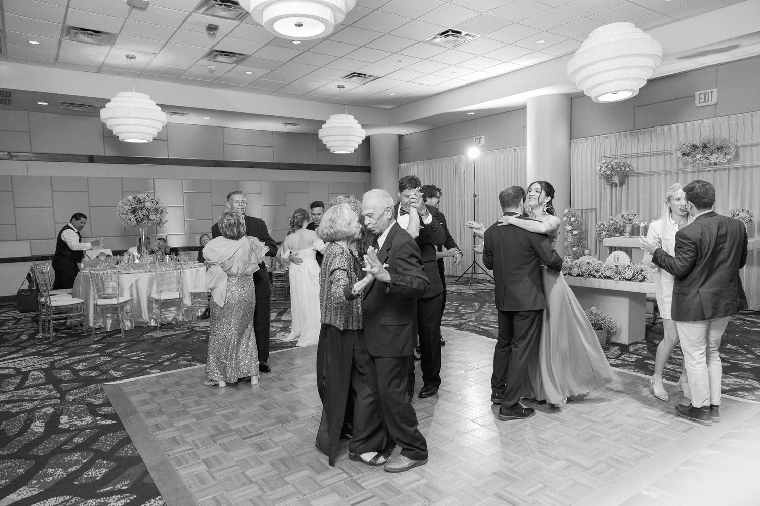 Black and white photo of multiple couples dancing at a wedding reception.