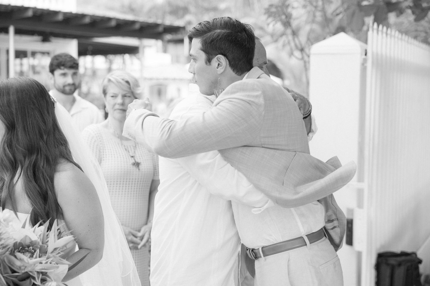 Black and white photo of wedding ceremony moments with guests watching.