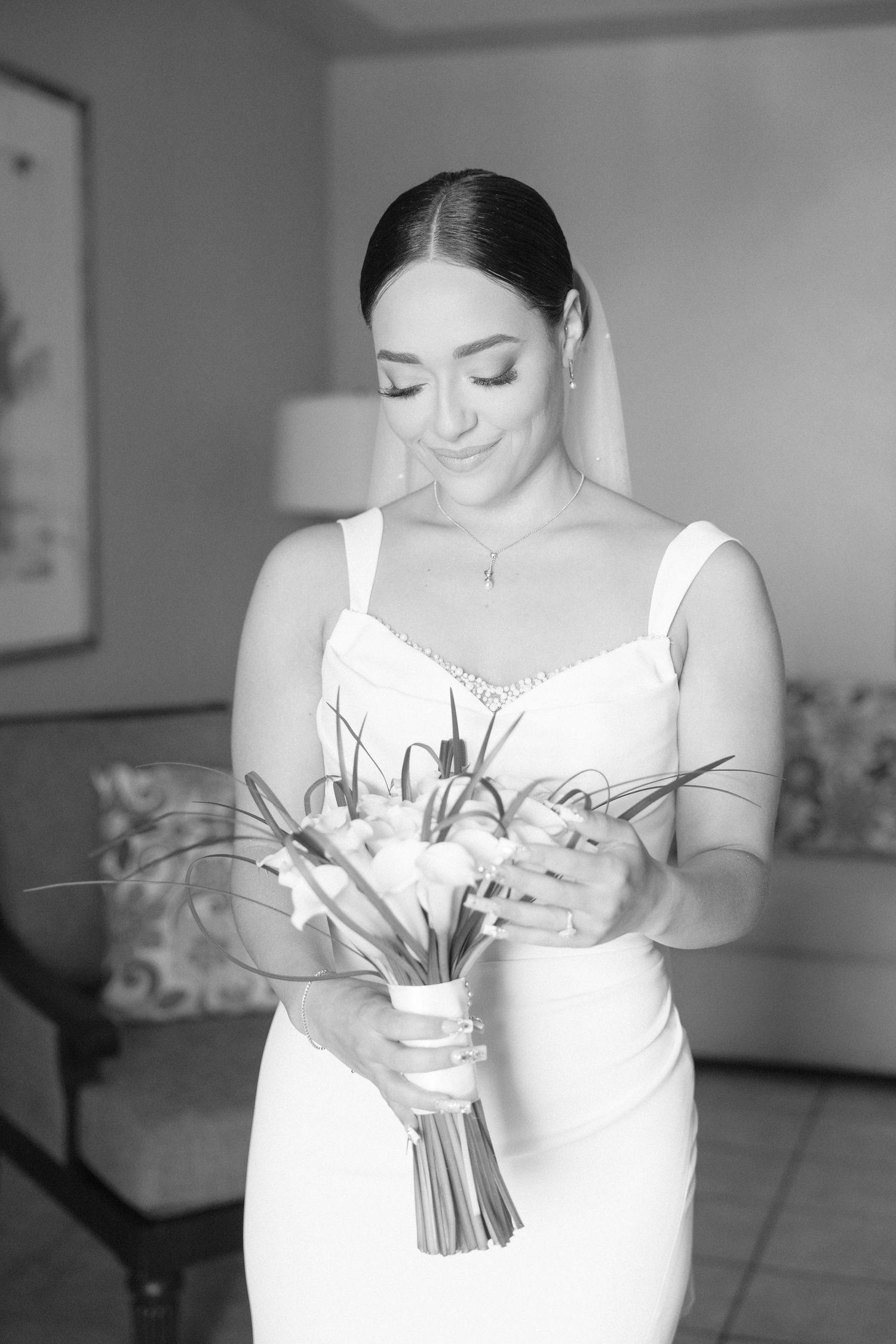 Black and white photo of a bouquet being held in white dress.