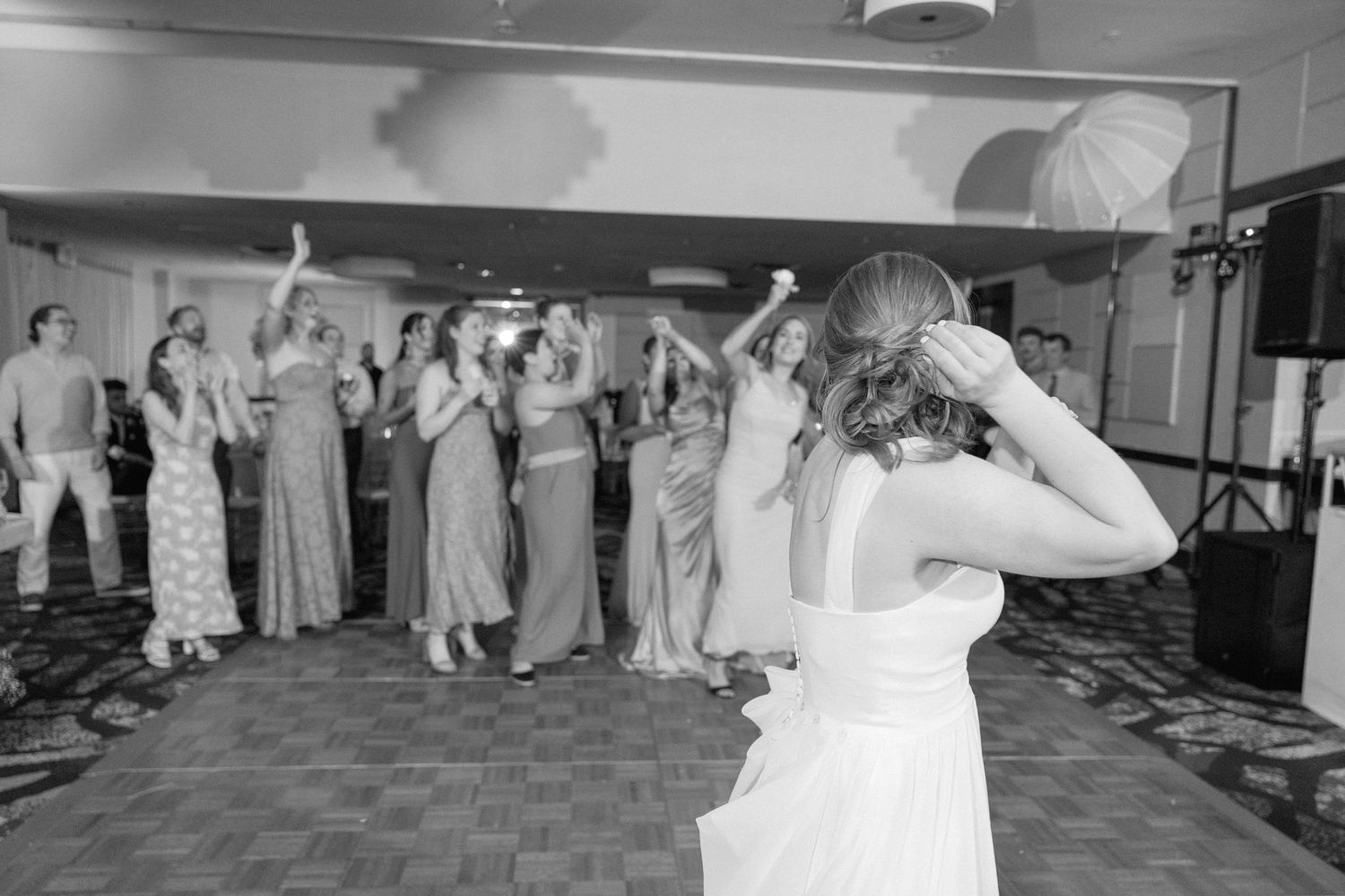 Wedding reception guests performing synchronized dance moves in a ballroom setting.