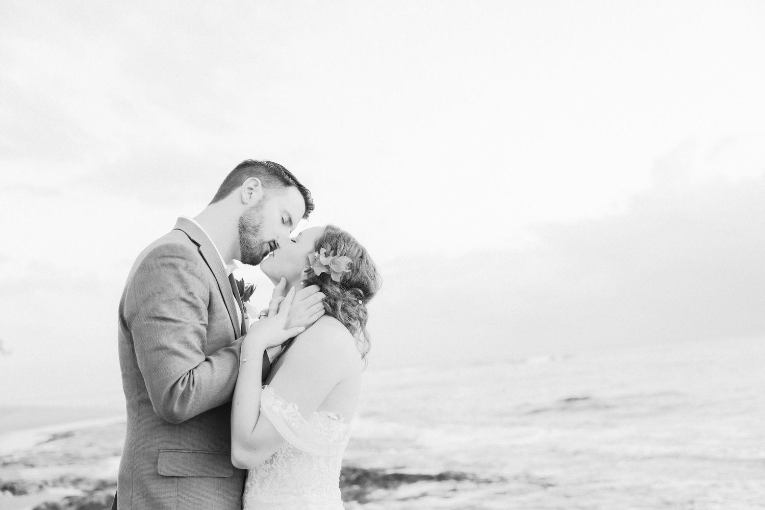 Black and white romantic portraits showing tender moments by the ocean.