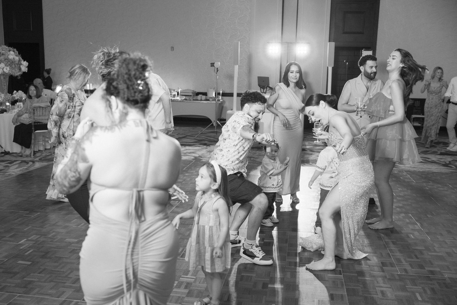 Wedding guests enjoying themselves while dancing in an elegant ballroom setting.