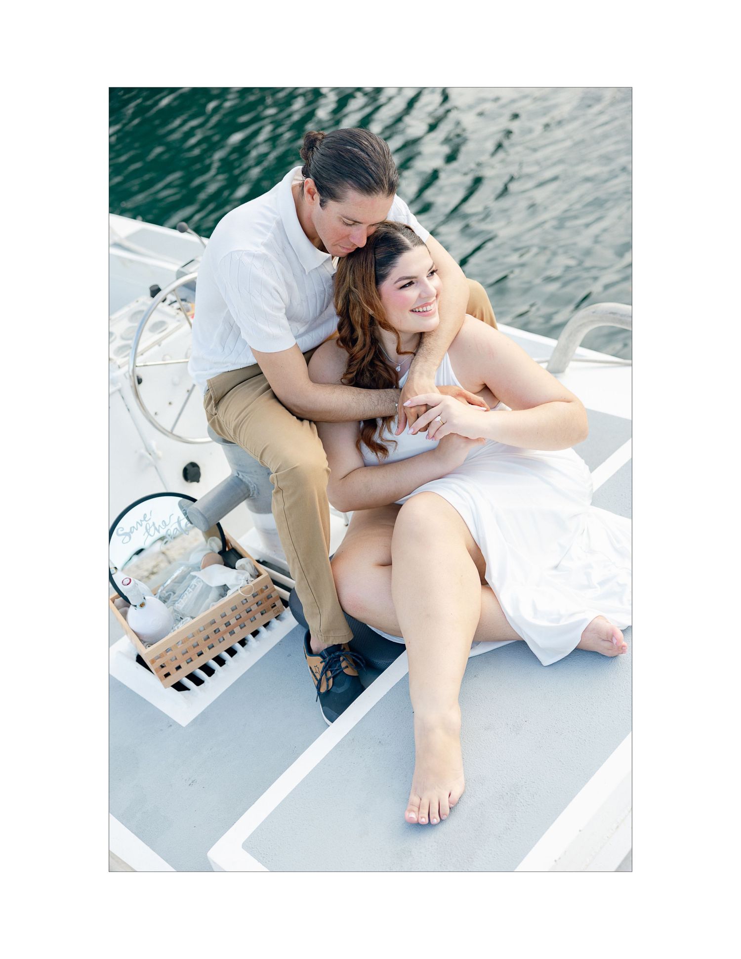 Couple sharing tender moments on white boat deck.