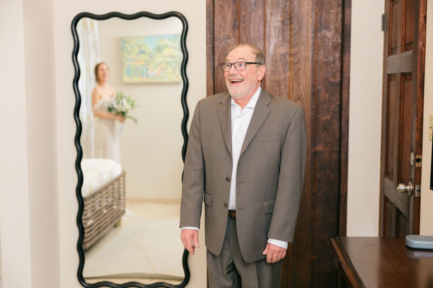 Emotional first look moment captured in front of dark wooden doors.