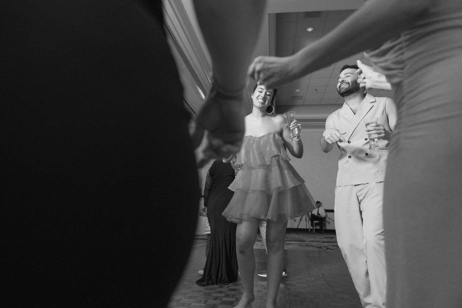 Guests dancing and socializing at an indoor wedding reception venue.