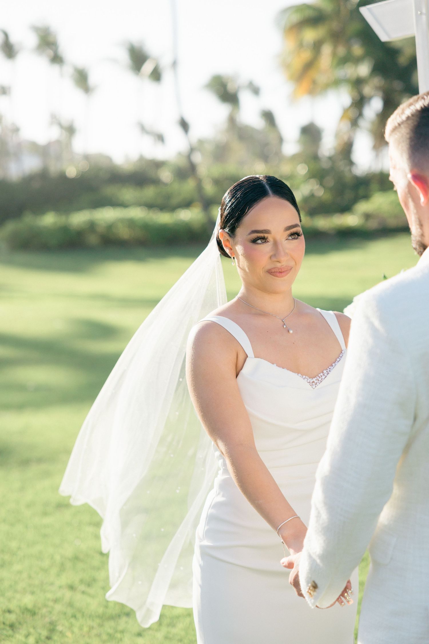 Romantic wedding couple shares intimate moments in a sunlit garden setting.