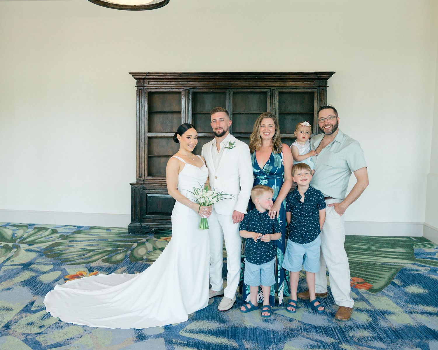 Wedding party and family members gathered for group photos in a modern venue setting.