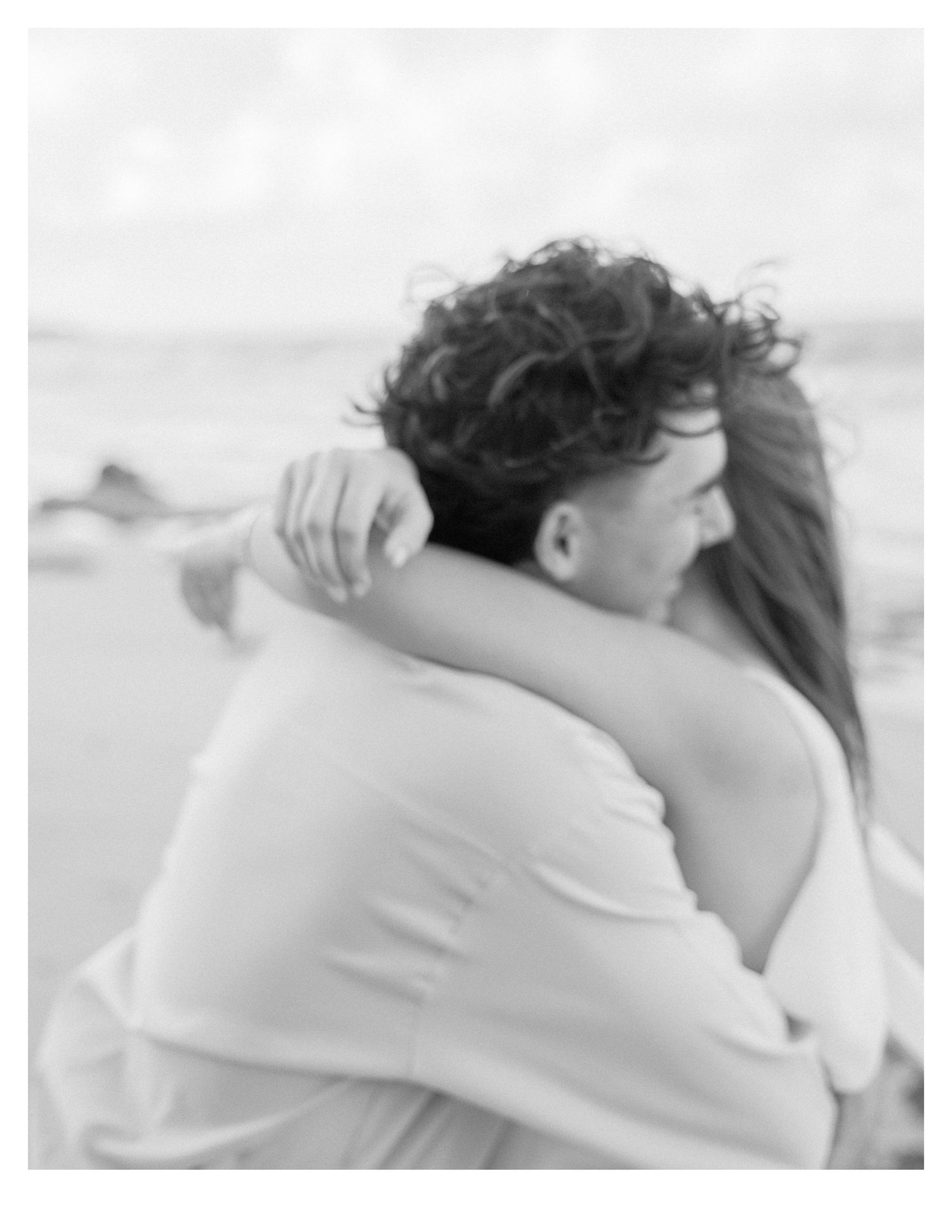 Romantic couple sharing an intimate moment in soft white tones.