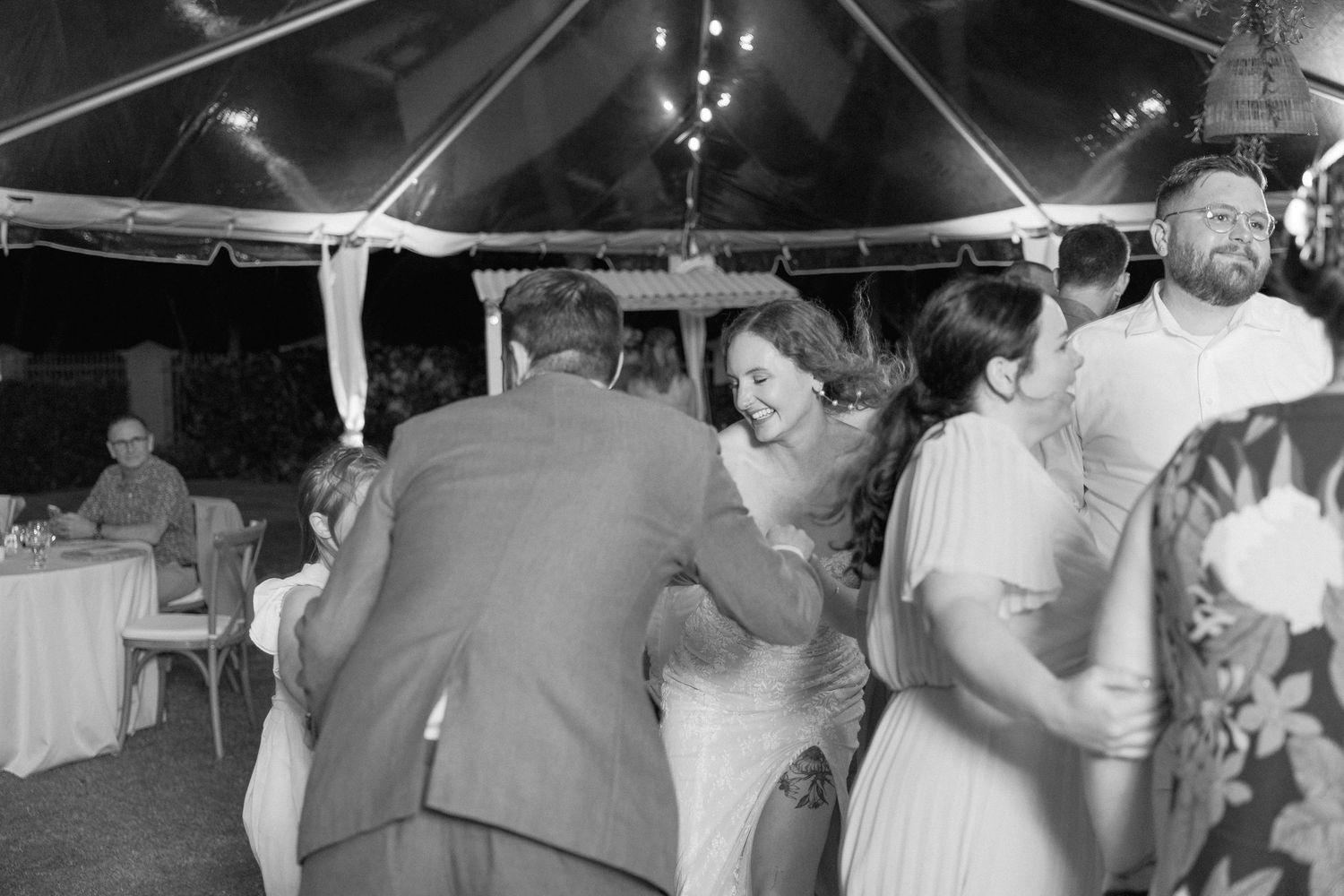 Black and white photos of wedding guests dancing and celebrating on a checkered dance floor.