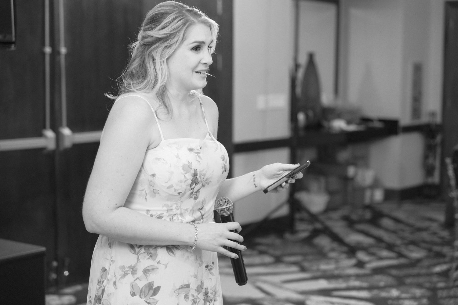 Black and white candid moments captured during wedding reception speeches.
